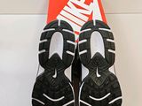 the pair of black and white shoes are on a white surface