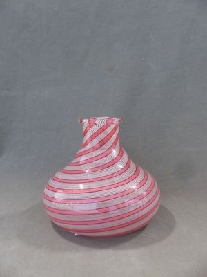 un vase rayé rouge et blanc posé sur une table