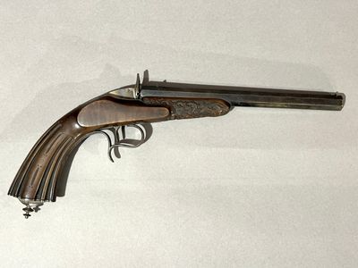 gros plan d'un pistolet sur une surface blanche