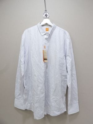 une chemise suspendue à un cintre accroché au mur, avec une étiquette dessus