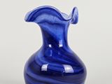 une image représentant un vase en verre bleu sur fond blanc