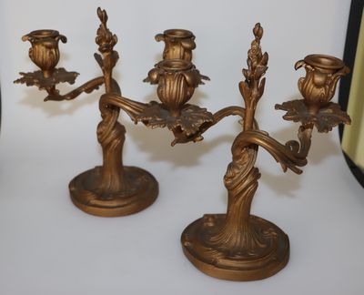 trois bougeoirs en laiton posés sur une table