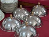 une table recouverte d'une nappe rouge, sur laquelle sont disposés des plats en argent