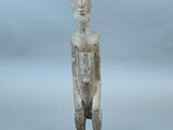 une vieille statue en bois d'un homme avec un chapeau sur la tête