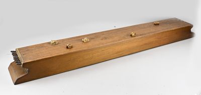 une boîte en bois surmontée de quatre boutons en laiton