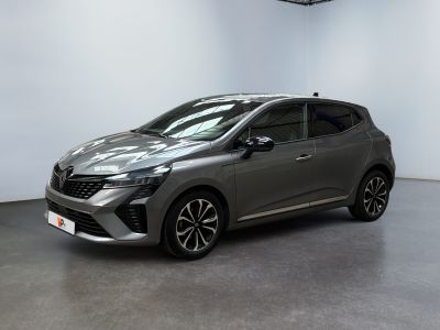 Une voiture grise est garée dans une pièce aux murs blancs.