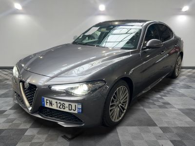 La berline Alfa grise est garée dans une grande pièce.