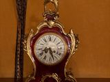 une horloge posée sur une table, avec un oiseau posé dessus