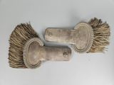 une paire de vieilles brosses en bois posées sur une surface blanche