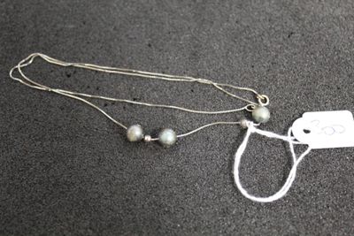 un collier en argent auquel est attachée une médaille