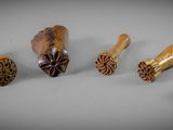 six pièces de bois sculpté sont disposées en rangée sur une surface grise