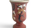a red vase with a bird design on it