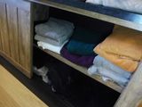a shelf with a bunch of folded clothes on it