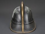 an old helmet with a metal handle on a gray background