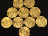 six gold sovereigns are arranged in a triangle on a black surface