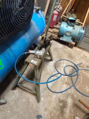 un compresseur d'air bleu posé sur le sol d'un garage