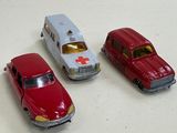 three toy cars sitting on a table next to each other