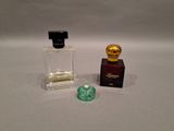 a small bottle of perfume next to a small bottle of perfume
