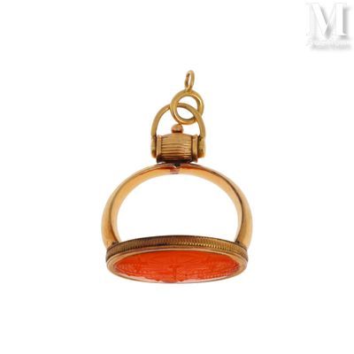 une image représentant un pendentif doré et rouge muni d'un anneau