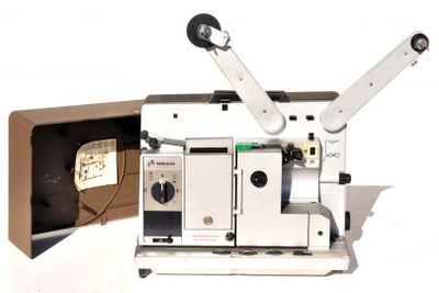 un vieux projecteur de cinéma posé sur une table à côté d'une boîte