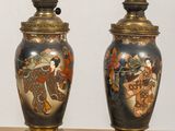 pair of antique japanese vases sitting on a table in front of a white wall