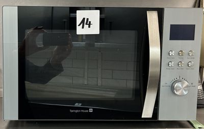 quelqu'un en train de prendre une photo d'un micro-ondes sur lequel figure le chiffre 4