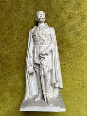 a statue of a man with a cape on it ' s head