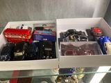 two boxes of toy cars and a bus on a glass table