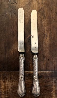 deux couteaux posés sur une table en bois