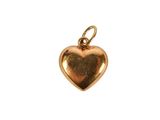 a close up of a gold heart charm on a white background