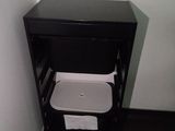 une petite armoire noire équipée de toilettes et d'un distributeur de papier essuie-mains