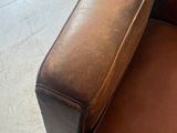 brown leather chair with footstop and ottoman in a room
