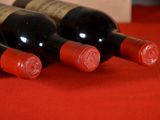 several bottles of wine are lined up on a red table