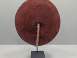 a close up of a red basket on a metal stand