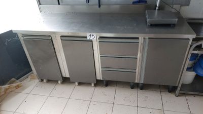 a kitchen with stainless steel cabinets and a white tile floor