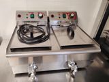 deux friteuses électriques posées sur un plan de travail en inox