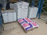 many bags of cement sitting on pallets in a warehouse