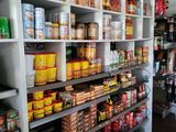 many shelves of food in the store with cans on them