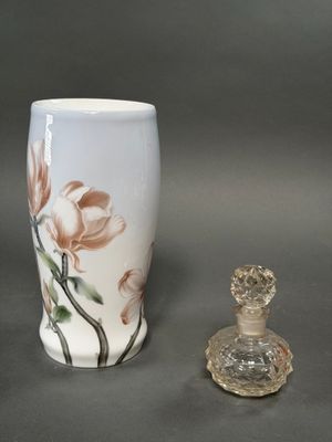 un petit vase et une petite bouteille en verre posés sur une table