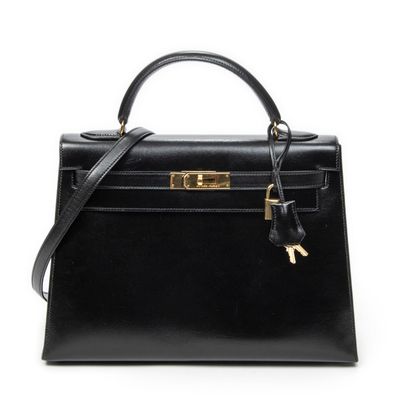 a black leather handbag with a gold lock on the handle