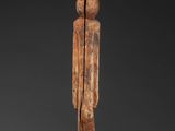 a wooden statue of a man with a long neck and legs