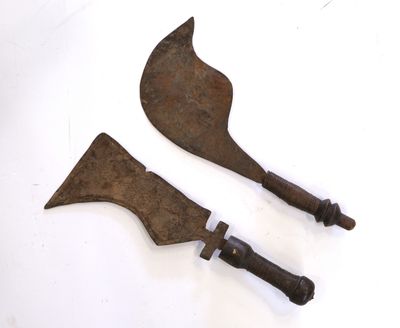 une paire de vieux outils métalliques rouillés posés sur une surface blanche