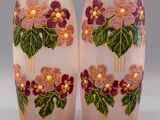 une paire de vases roses ornés de fleurs violettes et de feuilles vertes
