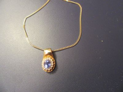 collier plaqué or avec un pendentif en pierre bleue sur une chaîne en or