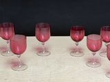 several wine glasses are lined up on a table with a black background