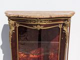 a glass display case with a marble top and gold trim
