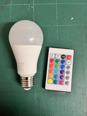 une télécommande posée à côté d'une ampoule sur une table