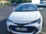 the front of a white toyota corollant parked in a parking lot