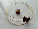 three pieces of jewelry on a white surface with a red bead