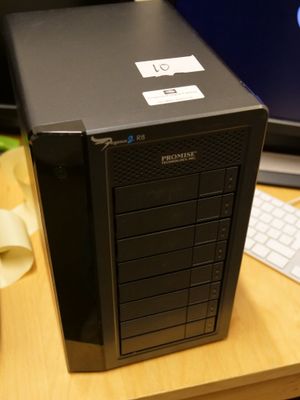 une tour d'ordinateur noire posée sur un bureau, avec un clavier et une souris